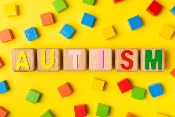 istock Autism awareness day.2 April world autism awareness day background.Design element.Care Awareness campaign for Autism.AUTISM text with colorful wooden puzzles, letters and cubes.Space for text.Top view 2201949658