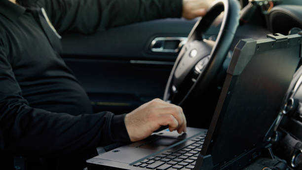 istock Police Officer Using Laptop in Patrol Car 2201950018