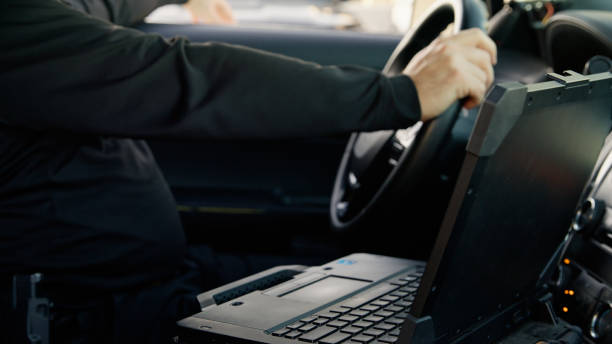 istock Police Officer Sitting in Patrol Car 2201950020