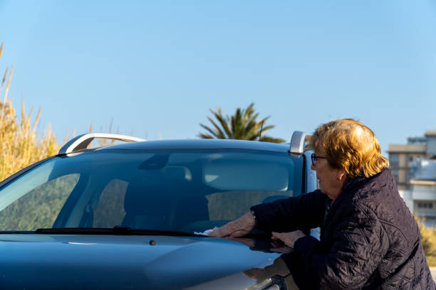 istock Retired woman cleans the windshield car 2201950201