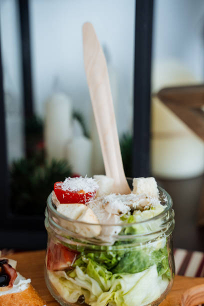 This vibrant salad is beautifully presented in a jar, accompanied by a charming wooden spoon, which makes serving and enjoying the fresh ingredients incredibly simple and delightful