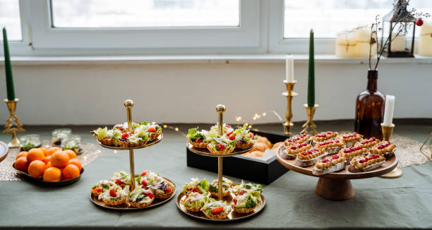 On a beautifully set table, there is a delightful spread of plates filled with various types of delicious food, accompanied by flickering candles that create a warm ambiance
