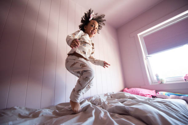 istock Cute girl jumping on the bed, happiness, joyful. 2201951800