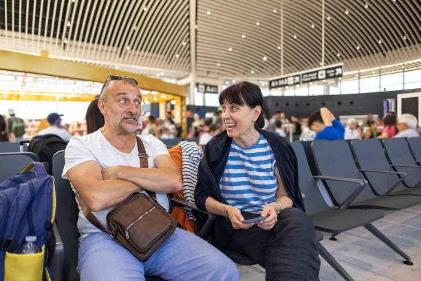 istock Husband making faces and his wife laughing while waiting plane 2201951932