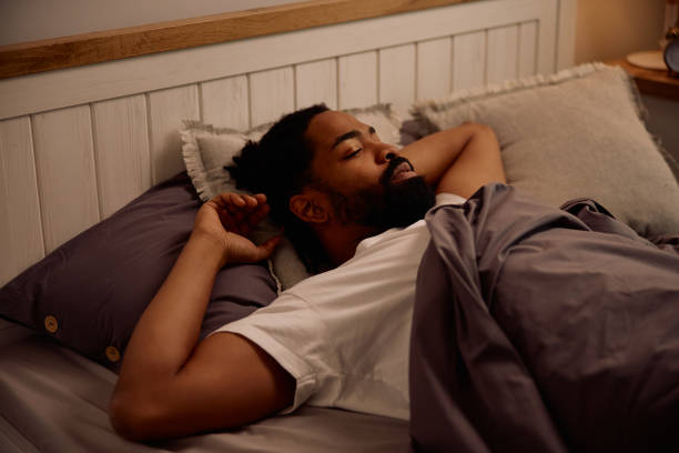istock Pensive black man lying down in bed at home. 2201952463