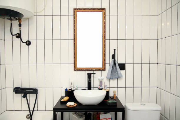 Stand with sink and supplies near dark tiled wall in bathroom with dim lights semi darkness twilight and mirror with frame mockup, copyspace. Contemporary bathroom detail of rustic loft interior concept.