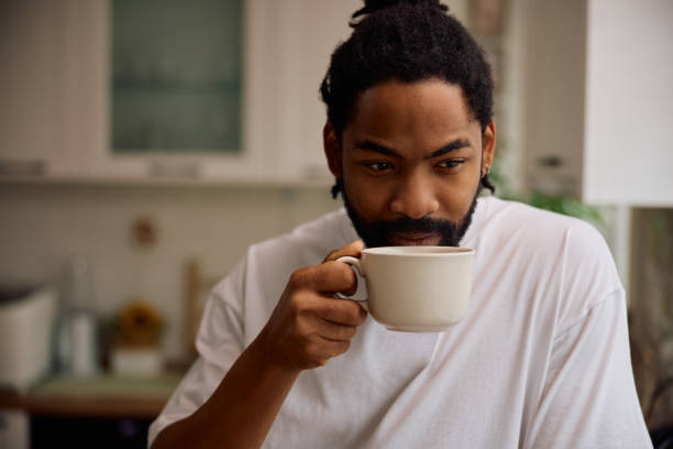 istock Thoughtful black man drinking coffee in the morning at home. 2201952631