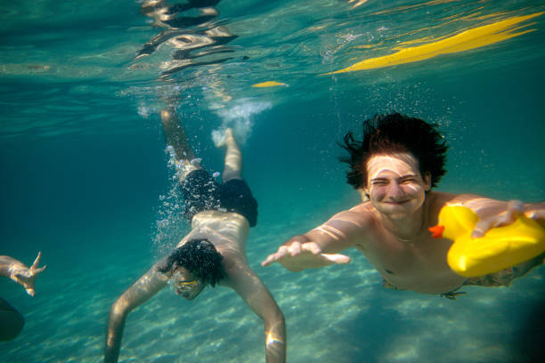 istock Adventurous friends take a thrilling dive into the sea 2201956079