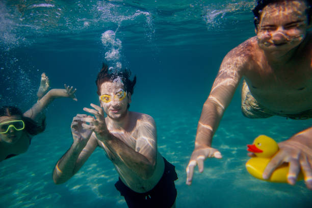 istock Friends diving into the ocean making air bubbles 2201956314