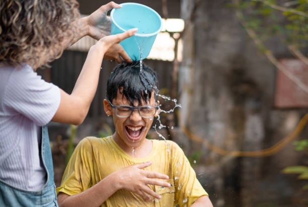 istock Siblings cooling off with a bucket of water 2201960266