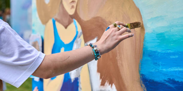 istock Young female artist painting mural in outdoors setting 2201965051