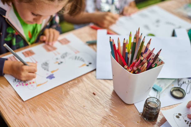 istock Child drawing with colors on wooden table 2201965060