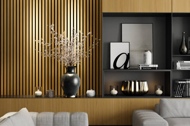 A stunning modern interior living room featuring a spacious layout with a large portal window opening to a patio. The design blends luxury and coziness with black-and-white tones, a light grey fabric sofa, and elegant seating. Warmth is added through beautifully crafted light yellow pine wood shelves and cabinets, enhancing the room’s natural aesthetic. A large carpet and stylish coffee table complete the sophisticated look. Perfect for renovation projects, architecture firms, real estate listings, designer portfolios, rentals, and interior design inspiration.