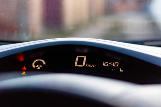 Car dashboard display shows zero speed and time at 16:40 in early evening light