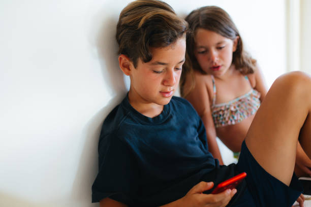 istock Happy children Laughing and interacting together with mobile phones 2201976867