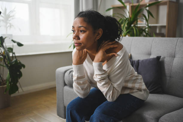 istock Distraught black woman sitting on a sofa at home 2201979769