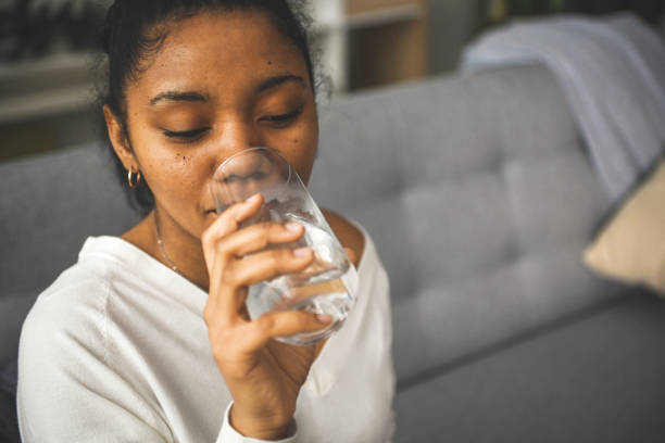 istock woman drinking water from a glass 2201981648