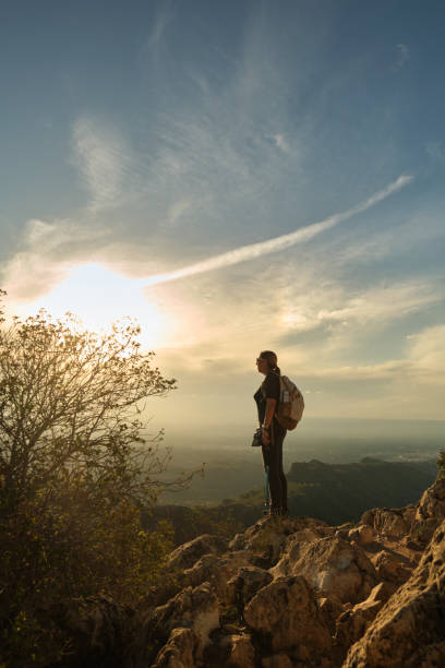 istock Woman with a backpack on her back on top of a mountain 2201981759