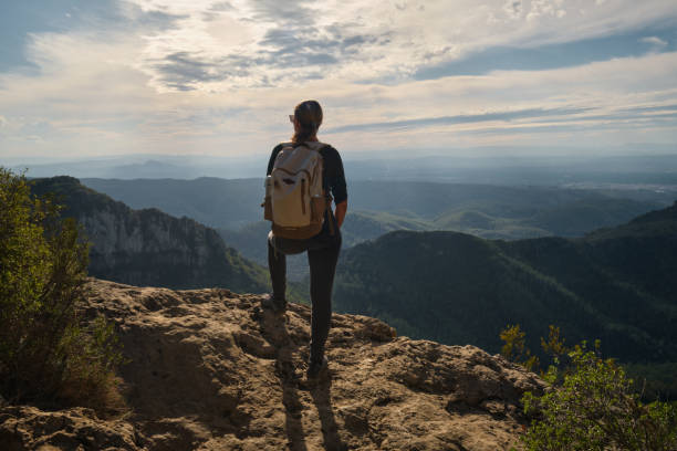 istock Woman with a backpack on her back on top of a mountain 2201981776