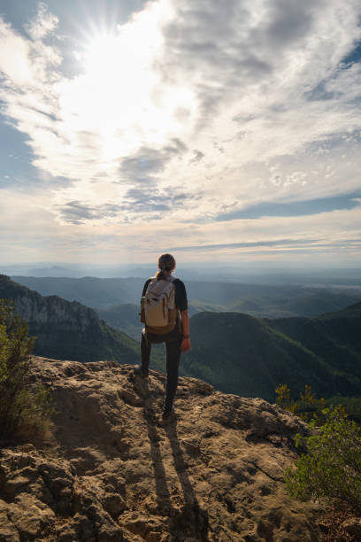 istock Woman with a backpack on her back on top of a mountain 2201981869