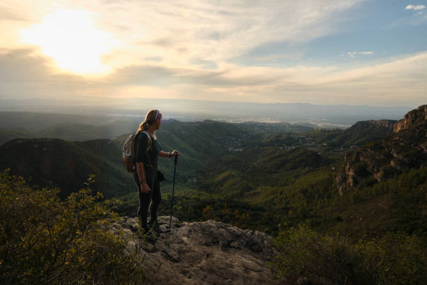 istock Woman with a backpack on her back on top of a mountain 2201981884