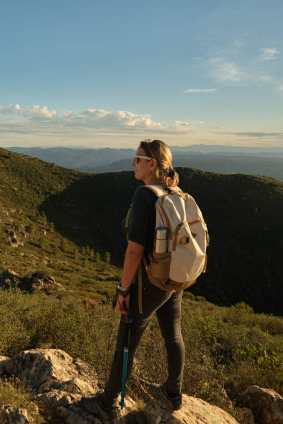 istock Woman with a backpack on her back on top of a mountain 2201981925