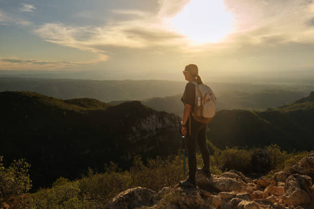 istock Woman with a backpack on her back on top of a mountain 2201982022