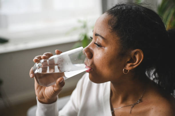 istock woman drinking water from a glass 2201982046