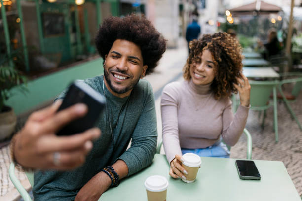 istock Happy couple taking a selfie while having coffee at outdoor cafe 2201987712
