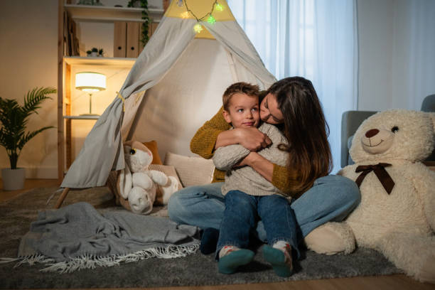 istock Mother embracing son in cozy teepee tent at home 2201988417