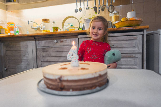 istock Cute Happy Child Smiles At Her Fourth Birthday Cake 2201990114