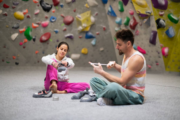 Couple preparing for climbing in indoor bouldering hall.