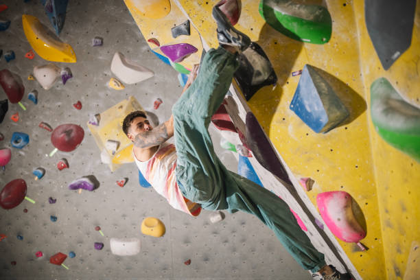 istock Climber gripping the artificial bouldering wall at an indoor climbing gym. 2201990194