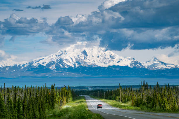 Car driving an empty road in Alaska