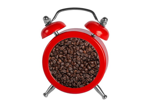 red alarm clock without numbers and freshly roasted coffee beans