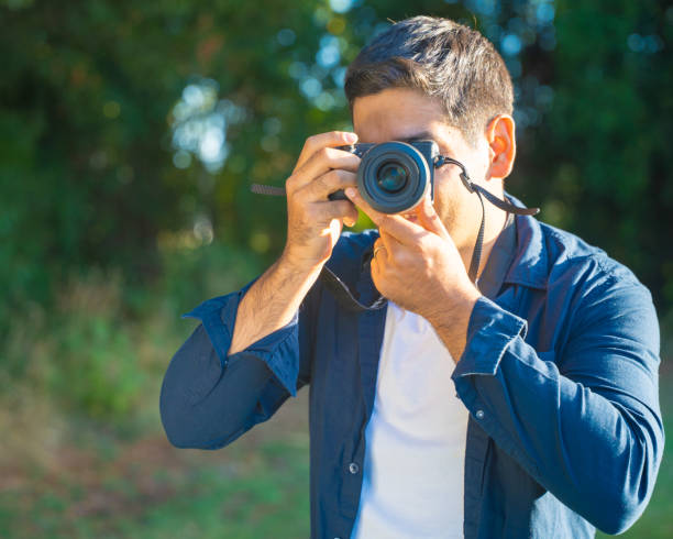 istock A man joyfully captures stunning outdoor photographs using his highquality camera gear 2202006486