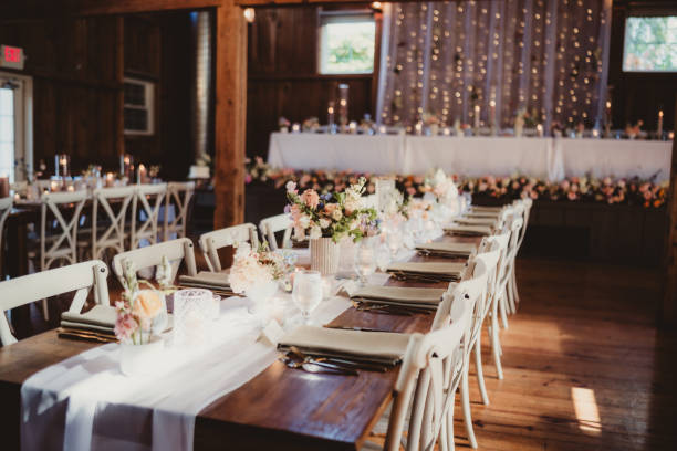 istock Wedding reception in barn with flower arrangements and candles 2202007414