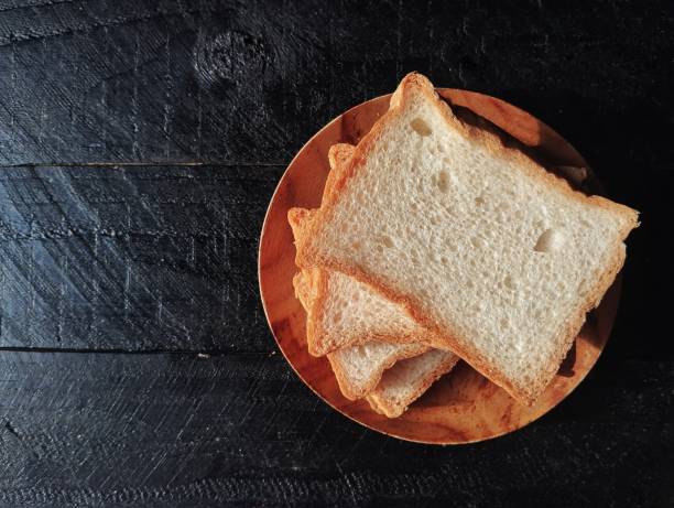 istock Pile of slices bread on black wooden table background 2202008191