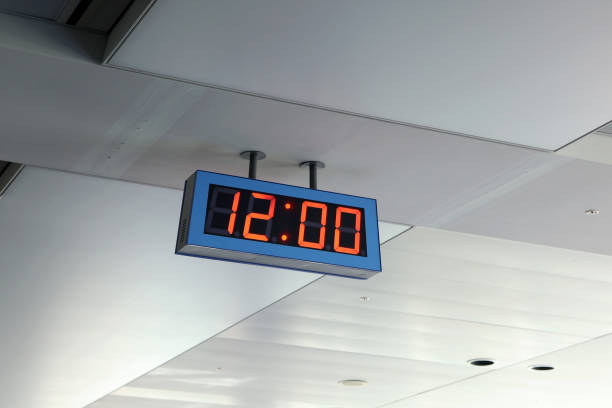 Electronic clock showing 12:00 indoors.