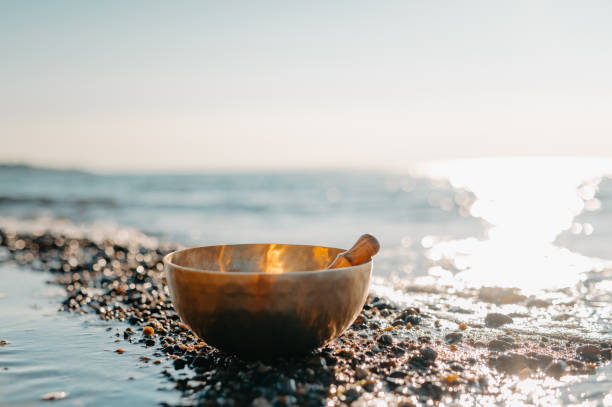 istock Tibetan Singing Bowl on a Rocky Beach with Ocean Waves at Sunset 2202009494