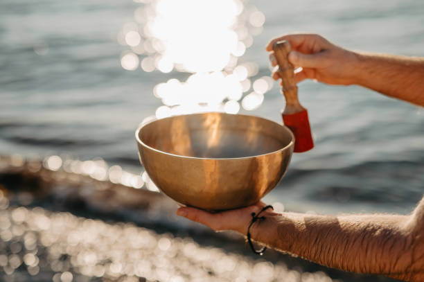 istock Man holding a Tibetan Singing Bowl at the Beach 2202009499