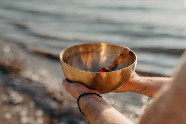 istock Person Holding a Tibetan Singing Bowl on a Beach at Sunset 2202009501