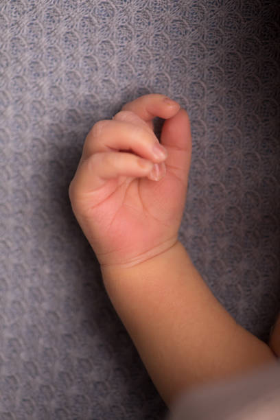 Sleeping baby clenched his fist