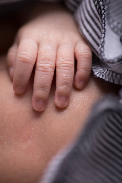istock Tiny newborn baby human hands and fingers 2202010754