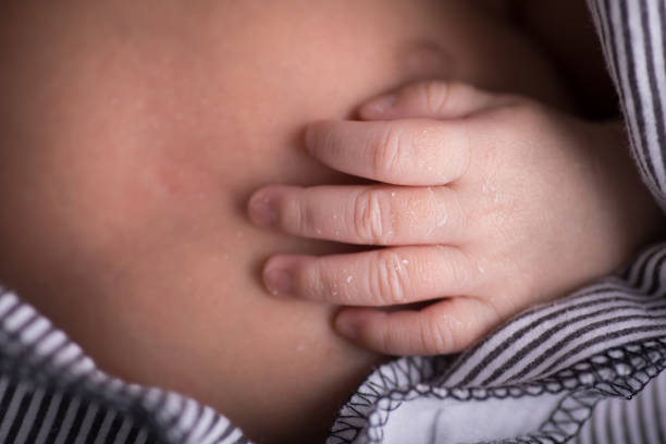 istock Tiny newborn baby human hands and fingers 2202010762