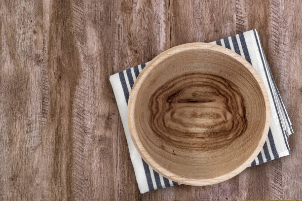 istock Rustic Handcrafted Wooden Bowl on Kitchen Cloth – Natural Tableware 2202010792