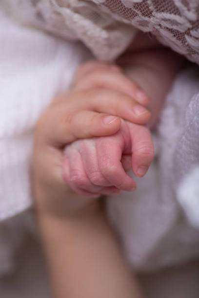 istock Tiny newborn baby human hands and fingers 2202010839