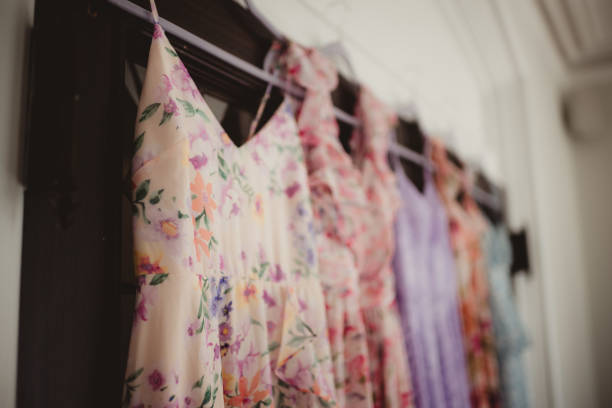 istock Assortment of women's floral pattern dresses hanging up 2202011369