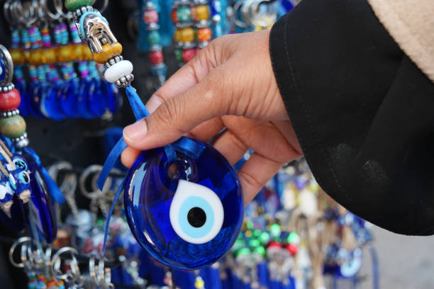 istock A Hand Selecting an Intriguing Blue Eye Amulet from a Delightfully Colorful Display 2202016171