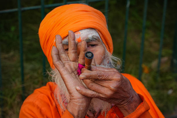 Sadhu smokes marijuana using a traditional chillum at the premises of the Doleswor temple during the Maha Shivaratri Festival in Bhaktapur, Nepal.